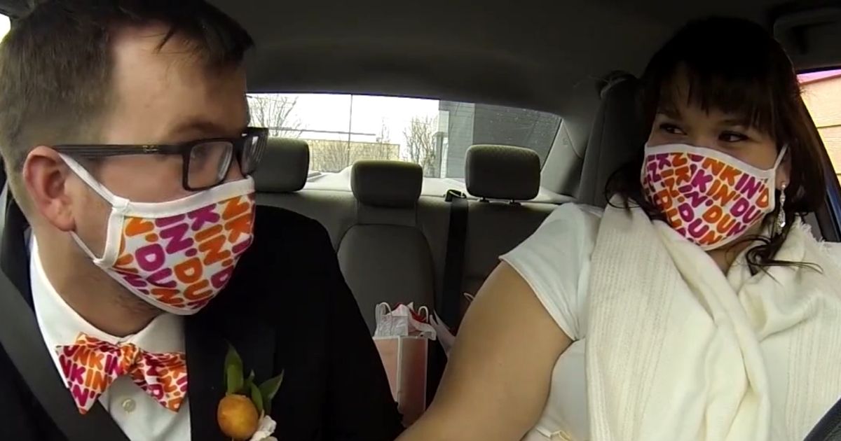 A couple exchange wedding vows at a Dunkin' Donuts drive-thru in New York.