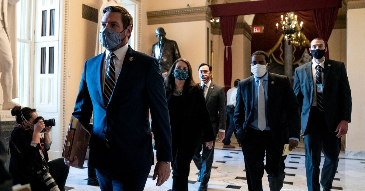 House impeachment manager Rep. Eric Swalwell of California, center, wears a protective mask while walking to the House floor during a vote on the impeachment of former President Donald Trump at the U.S. Capitol on Jan. 13, 2021, in Washington, D.C.