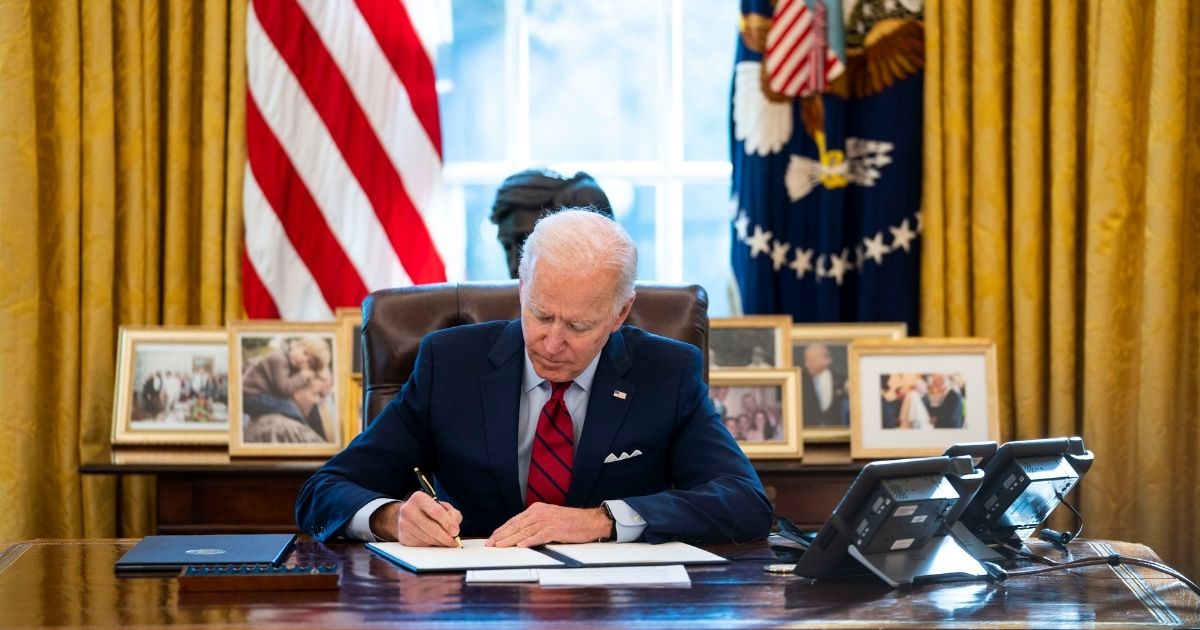 President Joe Biden signs executive actions in the Oval Office of the White House on Jan. 28 in Washington, D.C.