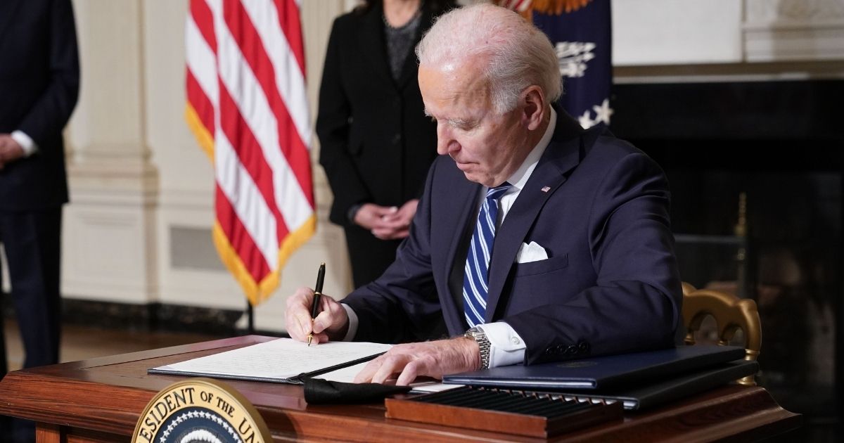 President Joe Biden signs executive orders after speaking in the State Dining Room of the White House in Washington, D.C., on Wednesday.