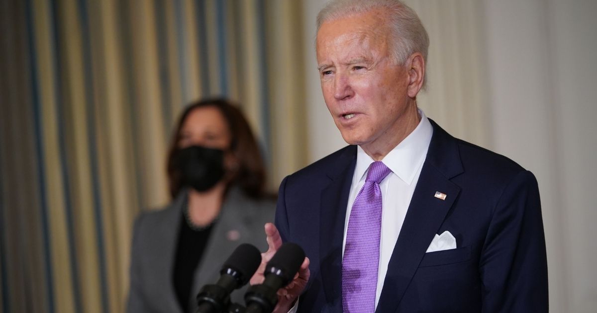 President Joe Biden speaks with Vice President Kamala Harris before signing executive orders in the State Dining Room of the White House in Washington, D.C., on Jan. 26, 2021.