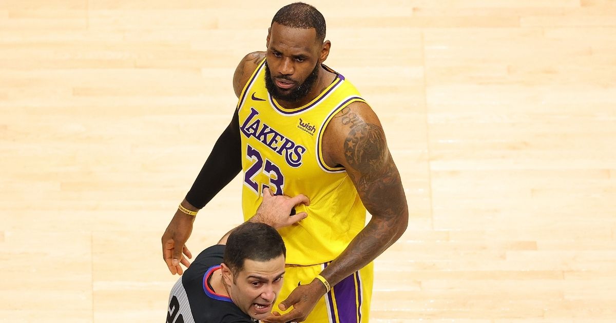 NBA official Mousa Dagher looks over at a fan courtside as he stands in front of LeBron James of the Los Angeles Lakers during the second half against the Atlanta Hawks at State Farm Arena in Atlanta on Monday.