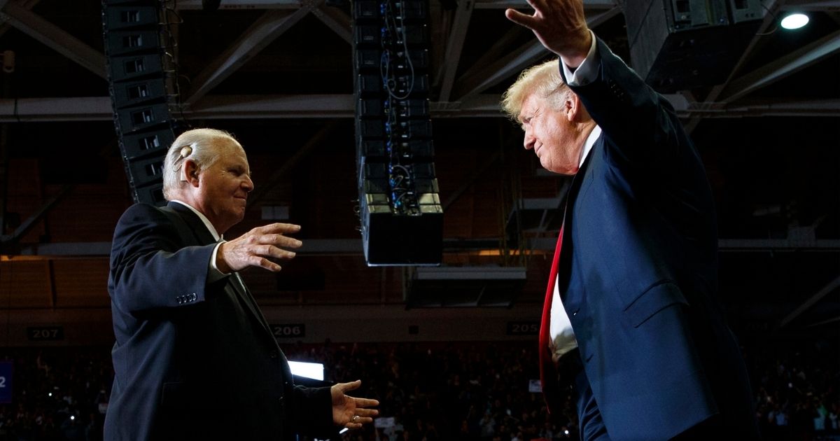 Then-President Donald Trump, right, opens his arms to Rush Limbaugh as he arrives to speak during a rally at the Show Me Center in Cape Girardeau, Missouri, on Nov. 5, 2018.
