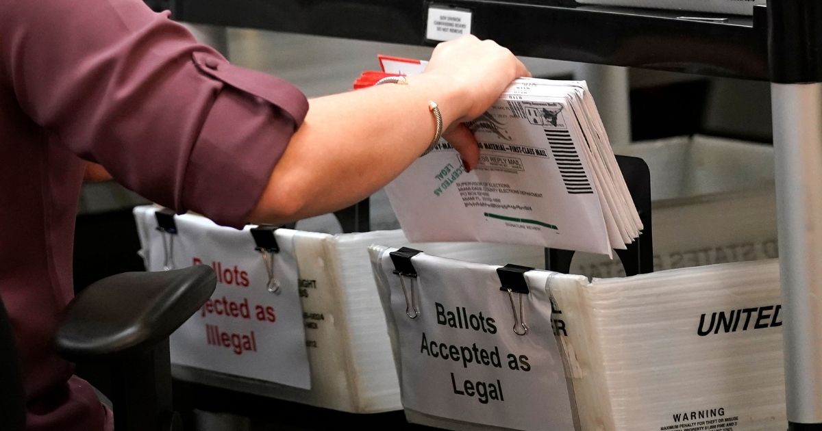 An election worker sorts mail-in ballots at the Miami-Dade County Board of Elections in Doral, Florida, on Oct. 26, 2020.