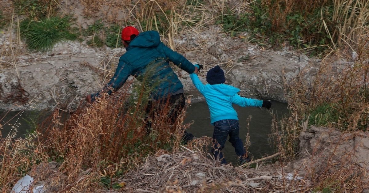 A Guatemalan migrant drags a boy across the Rio Grande natural border between El Paso, Texas, and Ciudad Juarez, Mexico, on Jan. 26.