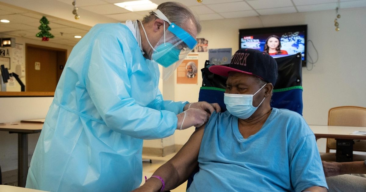 CVS pharmacist Gerard Diebner administers the COVID-19 vaccine to a resident of the Harlem Center for Nursing and Rehabilitation in New York on Jan. 15.