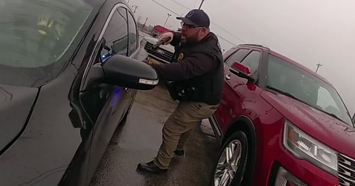 A police officer aims his firearm at a suspect in Hodgenville, Kentucky, after a chase.