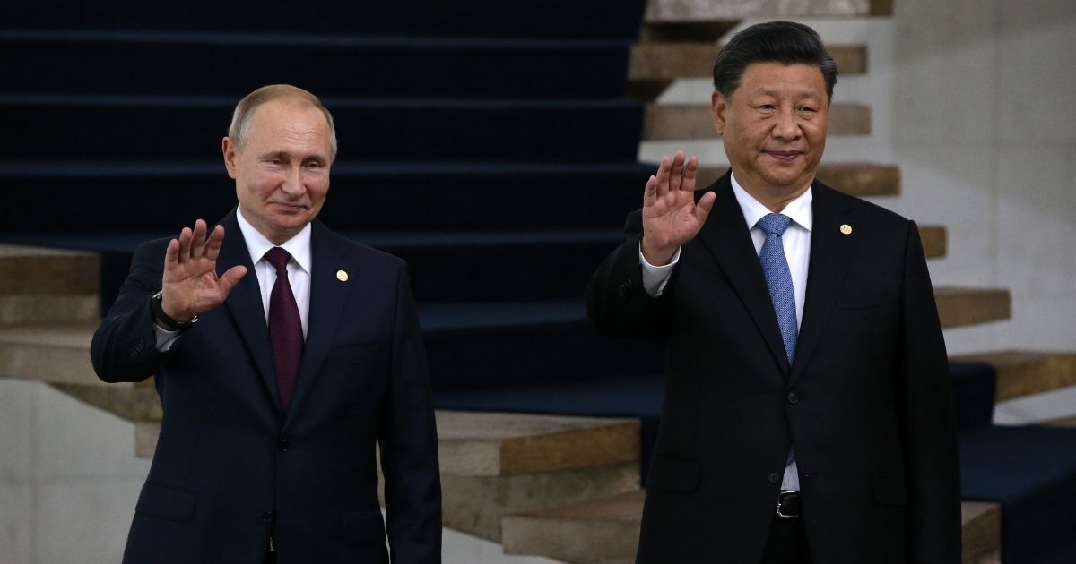 Russian President Vladimir Putin, left, and Chinese President Xi Jinping wave during a welcoming ceremony for the BRICS summit in Brasilia, Brazil, on Nov. 14, 2019.