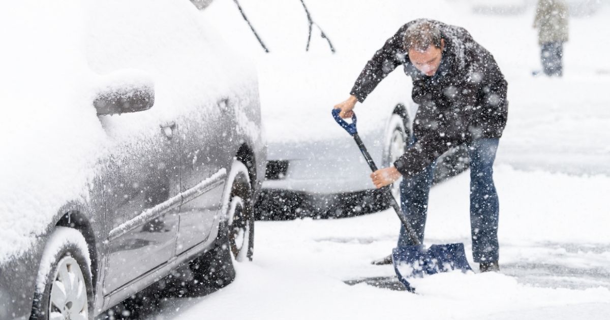 A man shoveling snow off a driveway is pictured in the stock image above.