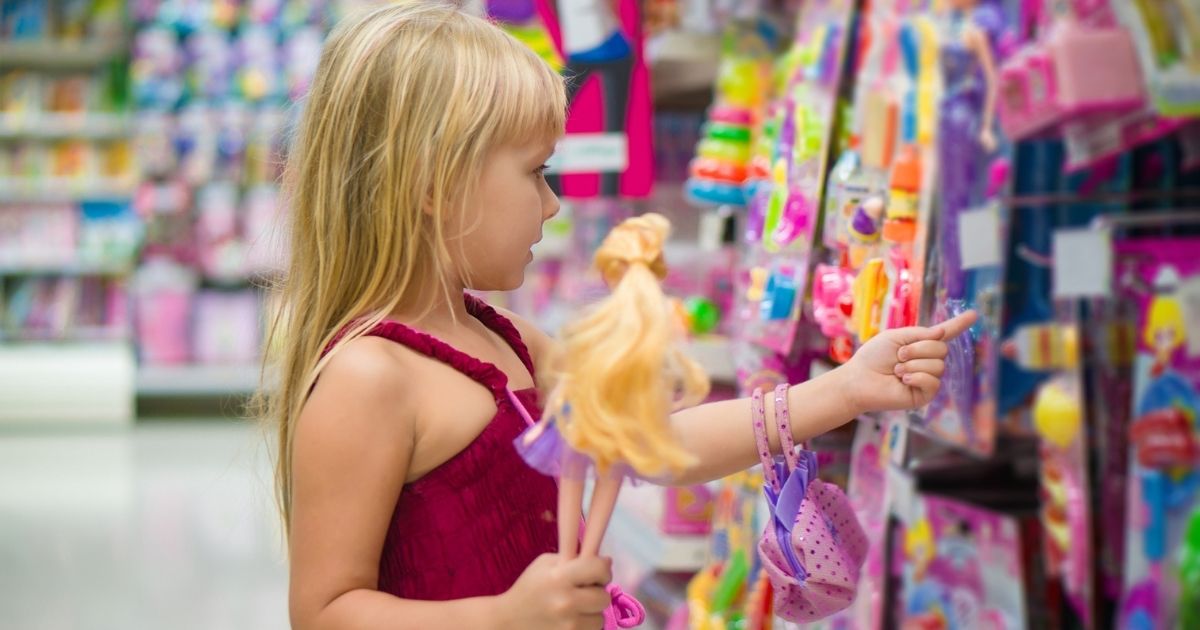 A girl looks at dolls in the toy section of a store in the stock image above.