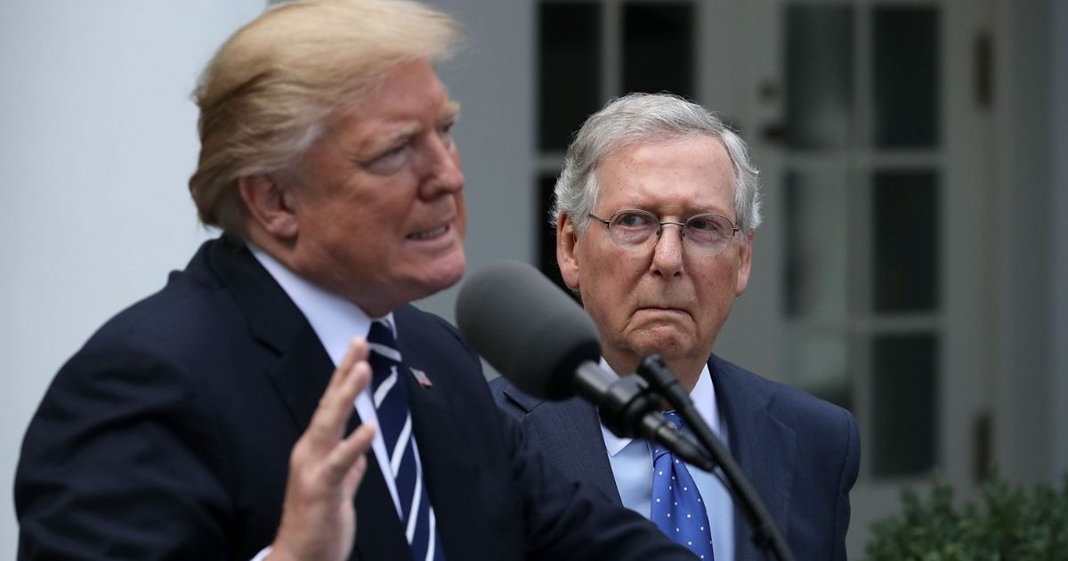 Then-President Donald Trump speaks to reporters in the White House Rose Garden while Republican Sen. Mitch McConnell looks on following a lunch meeting Oct. 16, 2017, in Washington.