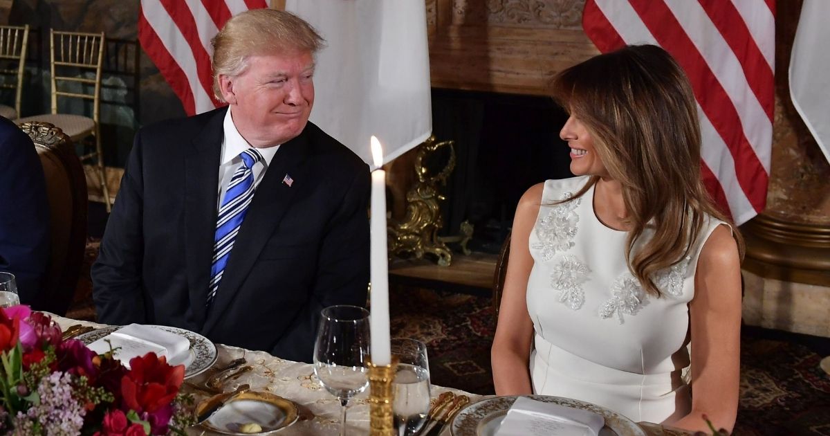Then-President Donald Trump speaks with his wife, Melania, during a dinner with Japanese Prime Minister Shinzo Abe and his wife, Akie, at Trump's Mar-a-Lago estate in Palm Beach, Florida, on April 18, 2018.