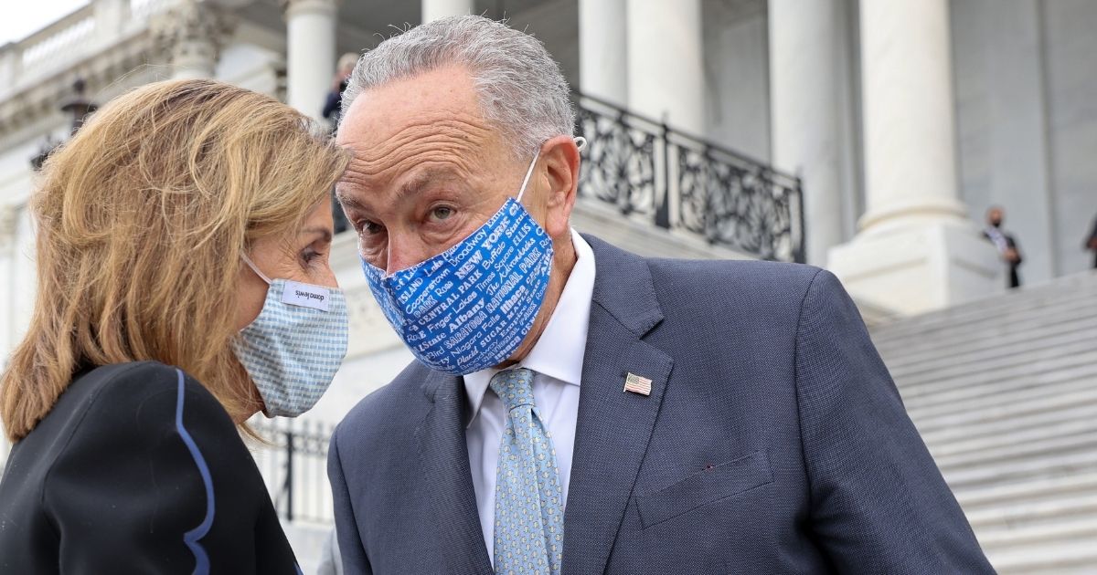 House Speaker Nancy Pelosi and then-Senate Minority Leader Chuck Schumer confer outside the Capitol after a Sept. 25 service honoring the late Supreme Court Justice Ruth Bader Ginsburg.