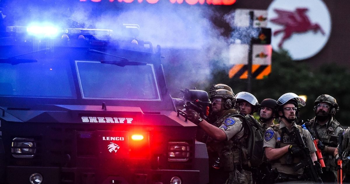 Law enforcement officers fire rubber bullets at rioters during a May 31 confrontation in Minneapolis. The Minneapolis City Council has voted unanimously to approve more funding for the city's police department only months after cutting its budget by $8 million.