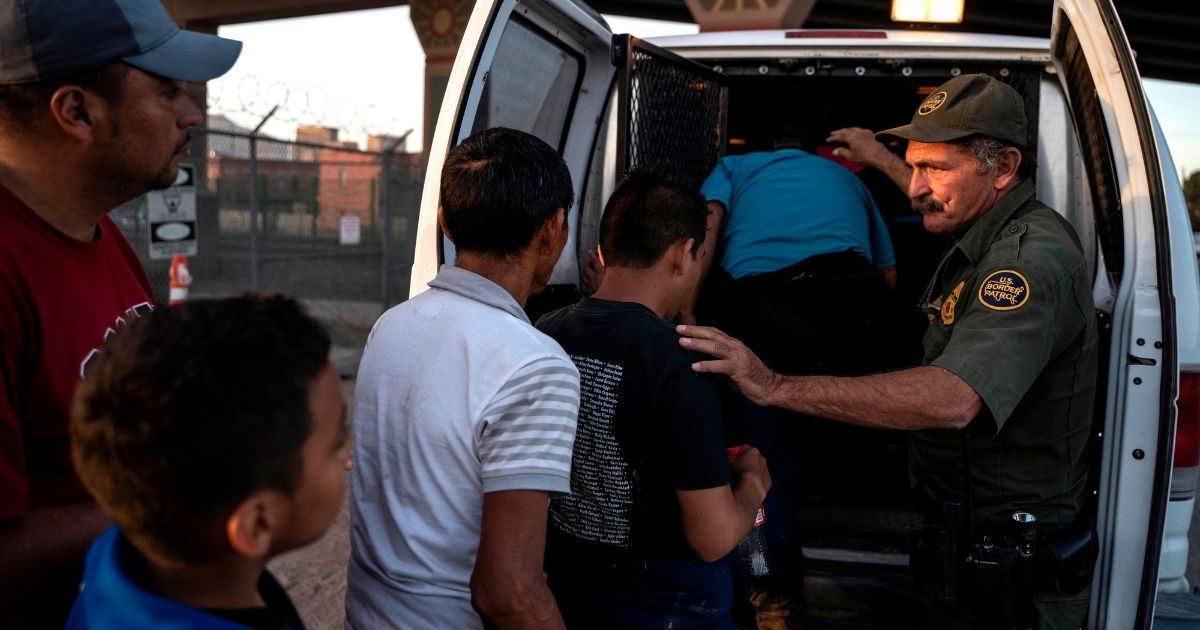 Central American migrants are boarded into a van by the U.S. Border Patrol in El Paso, Texas, in a file photo from May 2019, two months after then-President Donald Trump declared a state of emergency over illegal immigration.