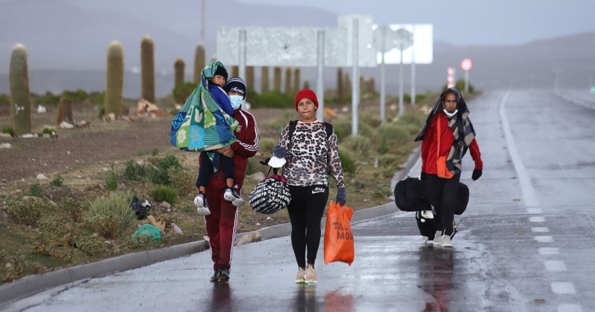 A Venezuelan migrant family walks along the road after crossing illegally through the border between Bolivia and Chile in Colchane, Chile, on Wednesday.