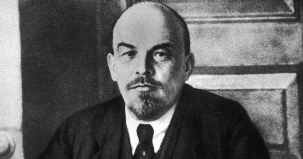 Pictured above is a portrait of Russian revolutionary leader Vladimir Lenin (1870 - 1924) sitting at a table during a meeting of the Sovnarkom.