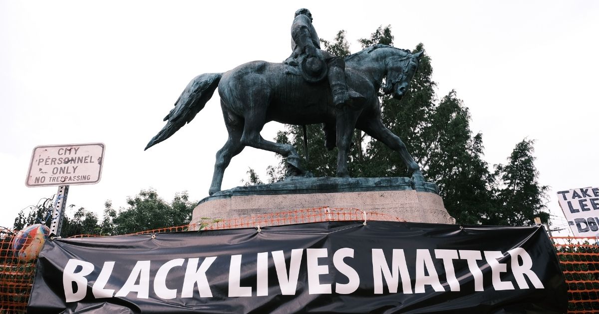 A statue of Robert E Lee with a banner that reads "Black Lives Matter" is seen on Aug. 12, 2020, in Charlottesville, Virginia.