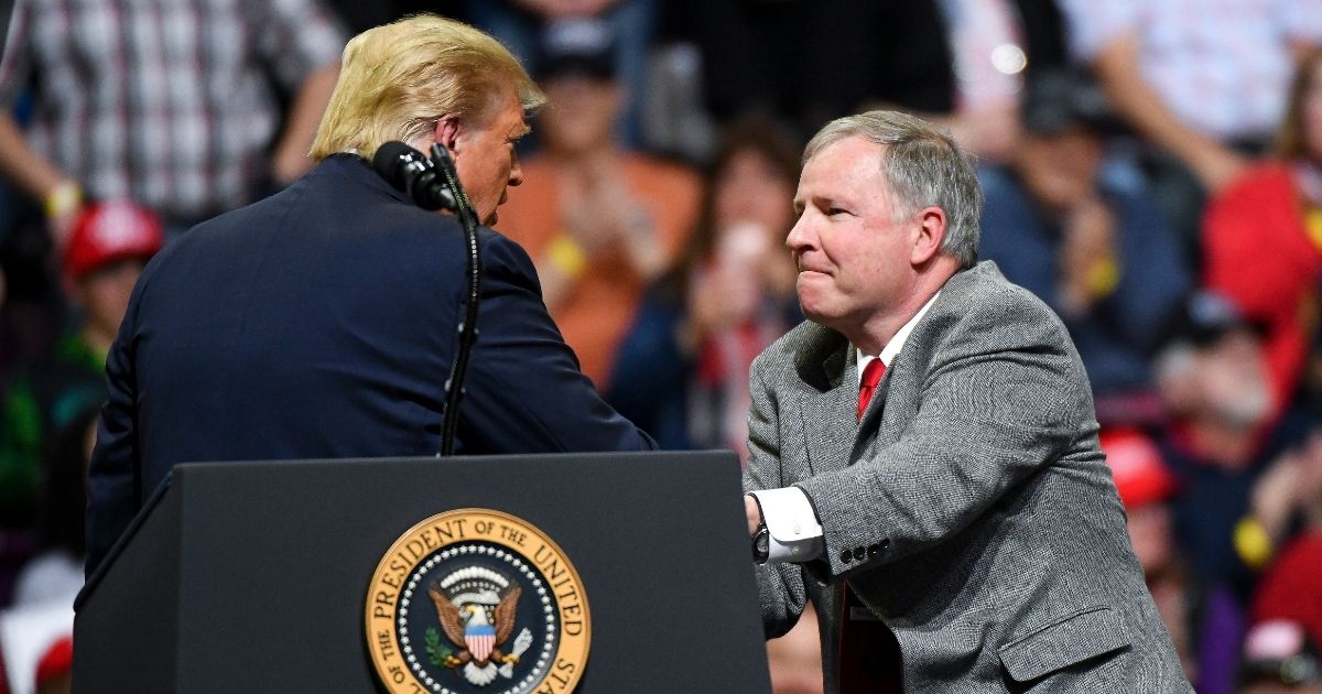 US Rep. Doug Lamborn shakes hands with President Donald Trump on stage during a rally on Feb. 20, 2020, in Colorado Springs, Colorado.