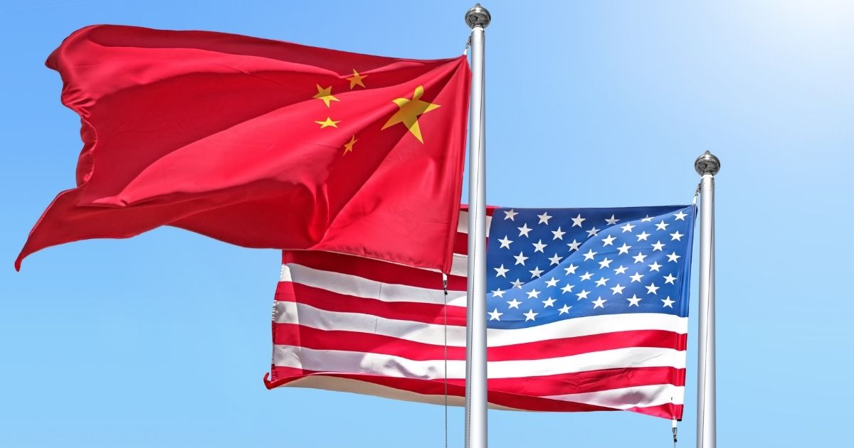 The Chinese and American flags fly in the above stock image.