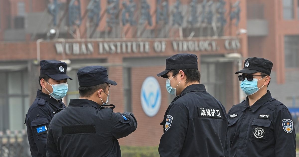 Security personnel stand guard outside the Wuhan Institute of Virology as members of the World Health Organization team investigating the origins of the coronavirus make a visit to the institute in China's central Hubei province on Feb. 3, 2021.