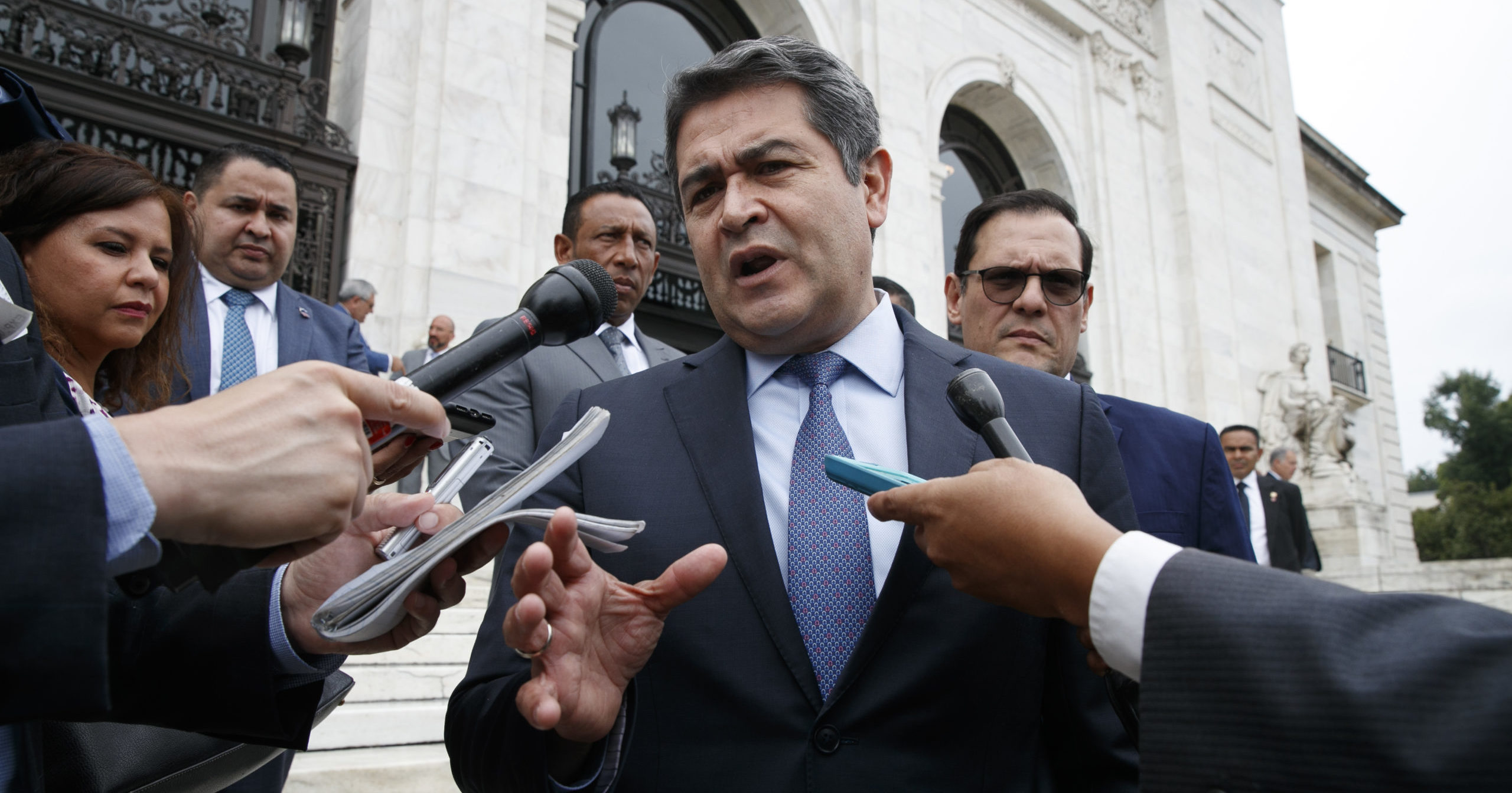 Honduran President Juan Orlando Hernández speaks to reporters as he leaves a meeting at the Organization of American States in Washington, D.C., on Aug. 13, 2019.