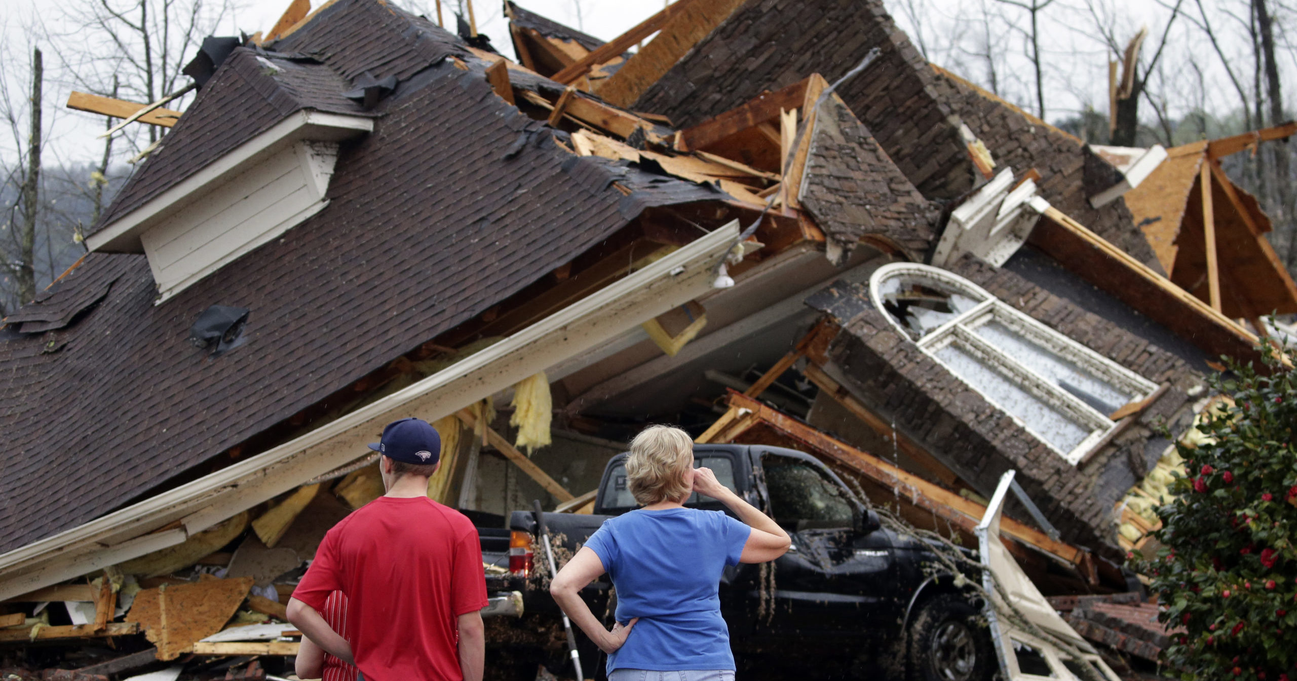 Residents survey damage to homes after a tornado touched down south of Birmingham, Alabama, on March 25, 2021.