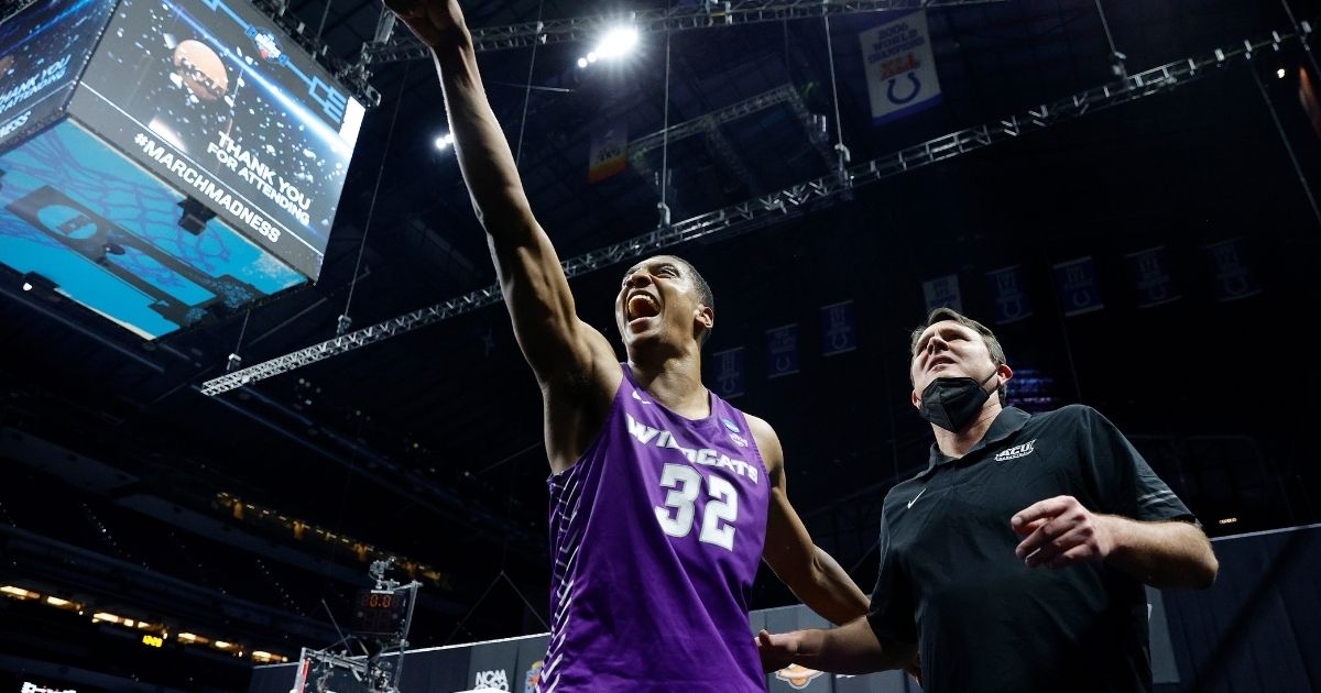Joe Pleasant, #32, and head coach Joe Golding of the Abilene Christian Wildcats celebrate after defeating the Texas Longhorns 53-52 in the first round game of the 2021 NCAA Men's Basketball Tournament at Lucas Oil Stadium on Saturday in Indianapolis.