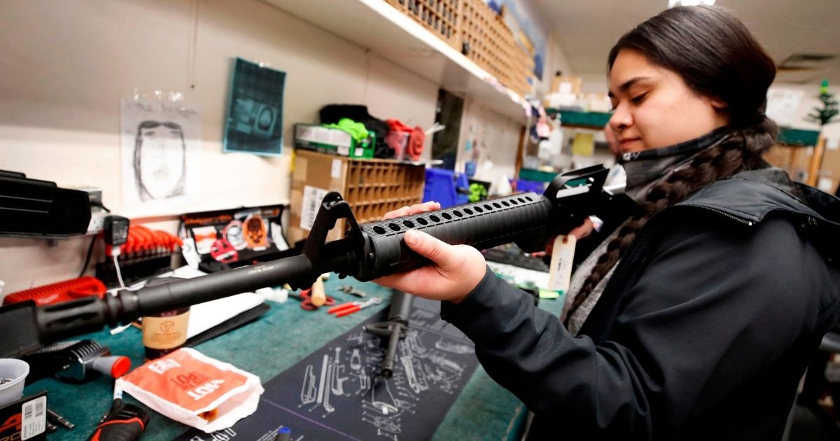 A worker gives a final check after she assembled an AR-15- style rifle at Davidson Defense in Orem, Utah, on Feb. 4.
