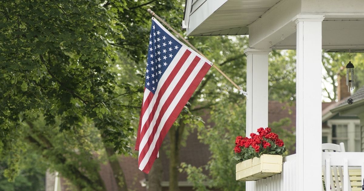 An American flag flies in front of a house.