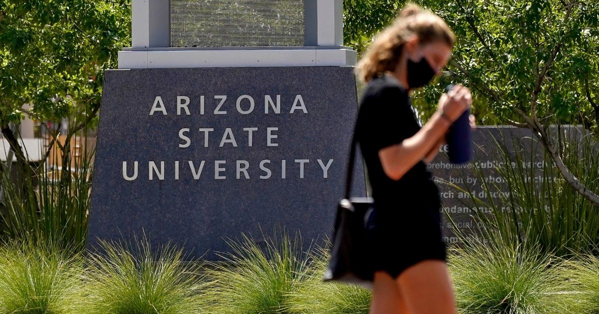 A pedestrian crosses a typically busy intersection on the campus of Arizona State University on Sept. 1, 2020, in Tempe, Arizona.