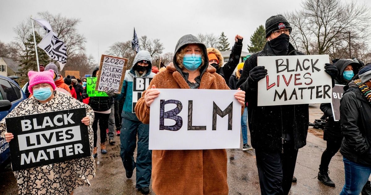 Protesters holding BLM signs march in Columbus, Ohio, on Dec. 24, 2020.