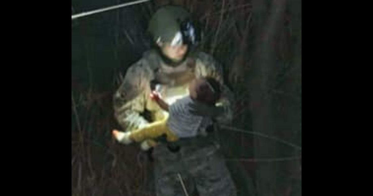 A rescuer holds a baby girl who was pulled out of the Rio Grande after she was thrown out by human traffickers.