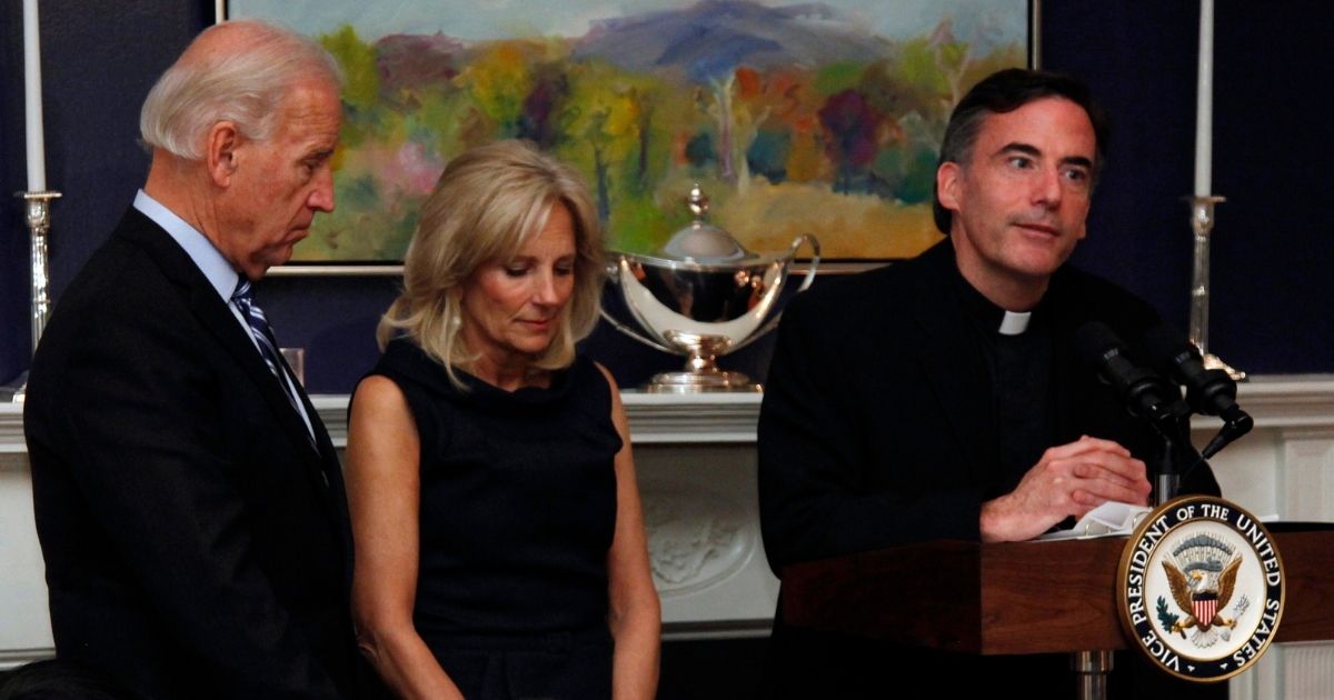 Then-Vice President Joe Biden and his wife, Jill, stand with heads bowed as the Rev. Kevin O'Brien says the blessing during a Thanksgiving dinner in Washington on Nov. 22, 2010.