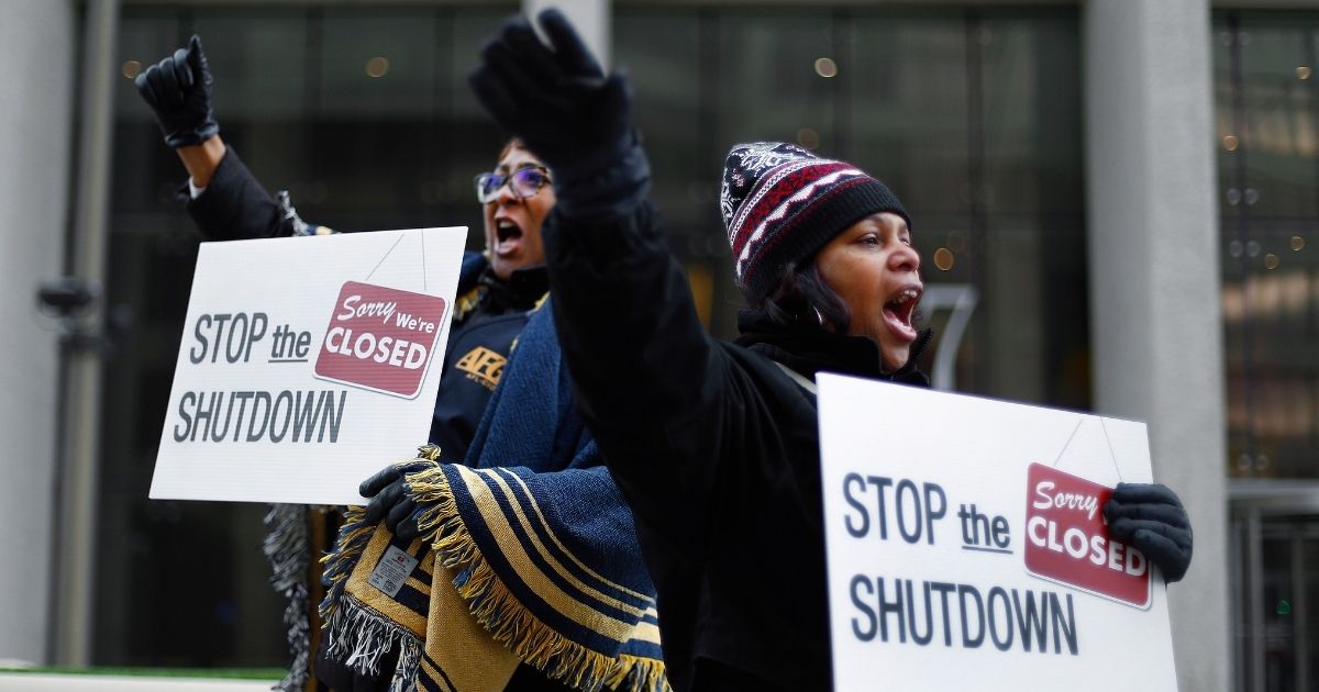 Cheryl Monroe, right, a Food and Drug Administration employee, and Bertrice Sanders, a Social Security Administration employee, rally to call for an end to the partial government shutdown in Detroit on Jan. 10, 2019.