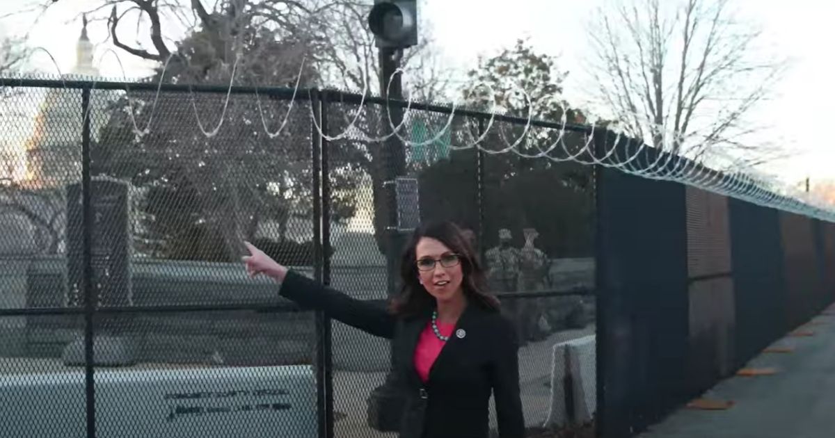 Republican Rep. Lauren Boebert of Colorado walks next to razor wire around the Capitol.