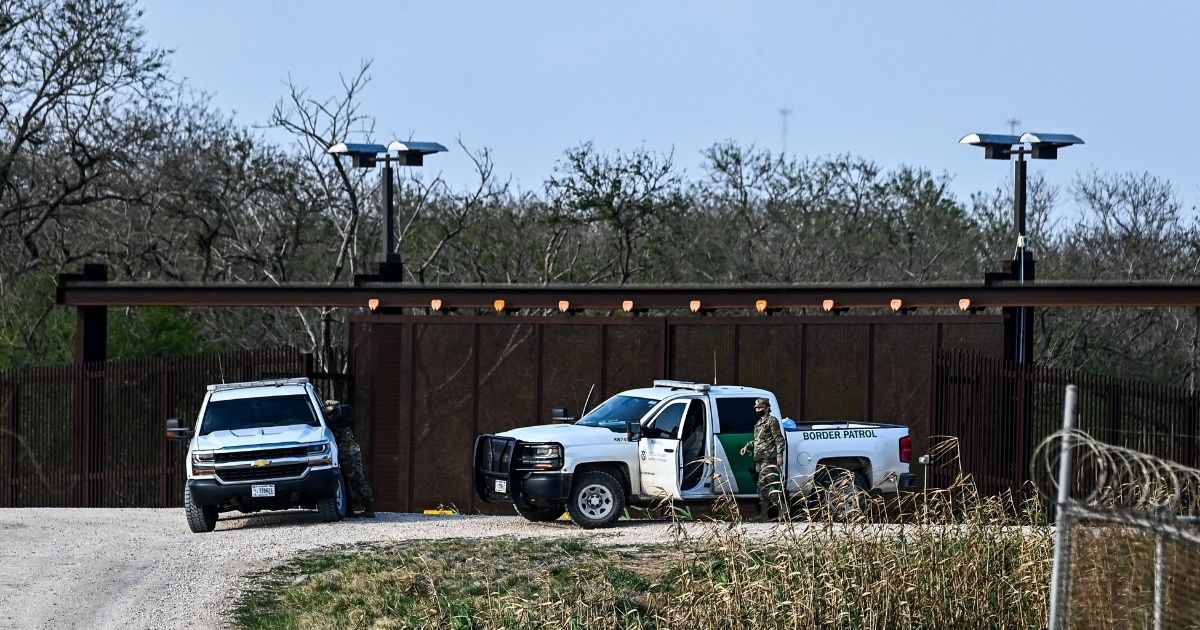 Border Patrol agents work on the bank of the Rio Grande near the Gateway International Bridge between the cities of Brownsville, Texas, and Matamoros, Mexico, on Tuesday.