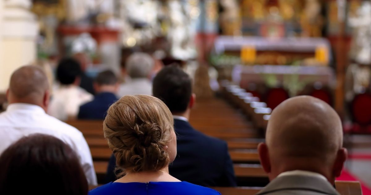 People sit in a Catholic church during Mass.