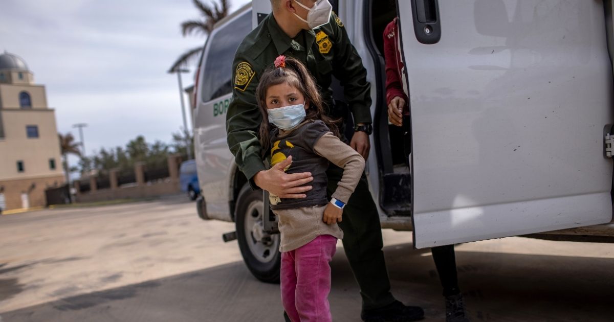 A U.S. Border Patrol agent delivers a young migrant to a bus station on Feb. 26, 2021, in Brownsville, Texas.