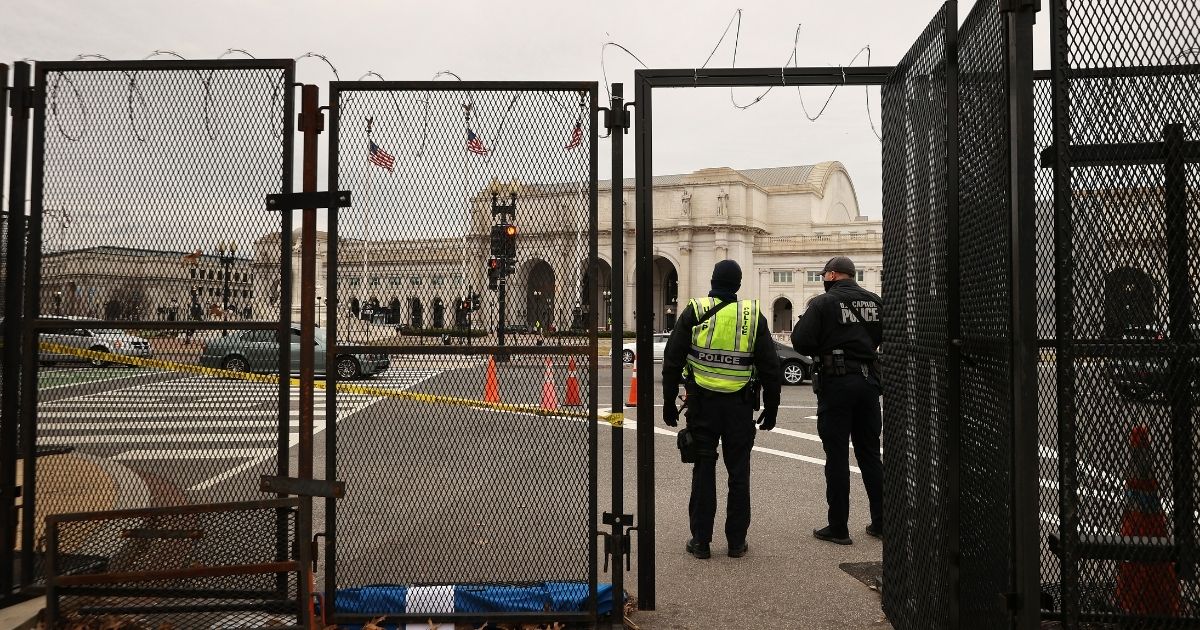 Capitol Police officers check people and vehicles as they enter the temporary security fence topped with concertina razor wire that surrounds the U.S. Capitol on March 16 in Washington, D.C.