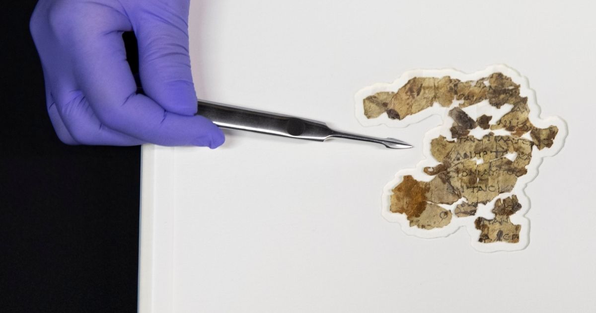 Israel Antiquities Authority conservator Tanya Bitler shows newly discovered Dead Sea Scroll fragments at the Dead Sea Scrolls conservation lab in Jerusalem on Tuesday.