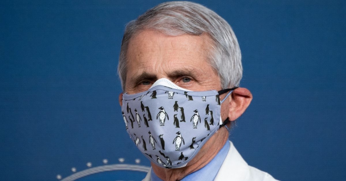 Dr. Anthony Fauci, the White House's chief medical adviser on COVID-19, wears two masks as he listens to President Joe Biden speaks about coronavirus vaccine during a media event at the Eisenhower Executive Office Building in Washington on Feb. 25.