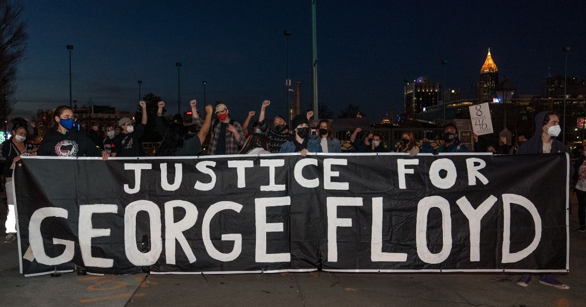 Demonstrators hold a vigil in honor of George Floyd on Monday in Atlanta.