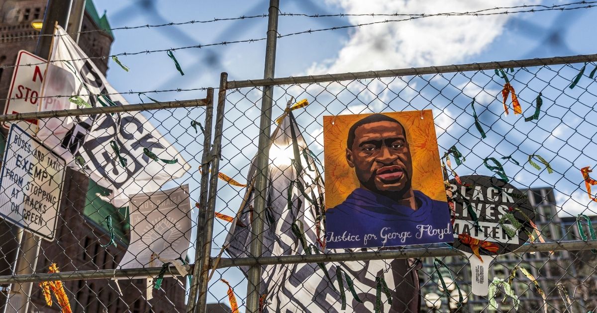 A poster with George Floyd's picture and a sign reads that "I Can't Breathe" hang from a security fence outside the Hennepin County Government Center in Minneapolis on Wednesday.