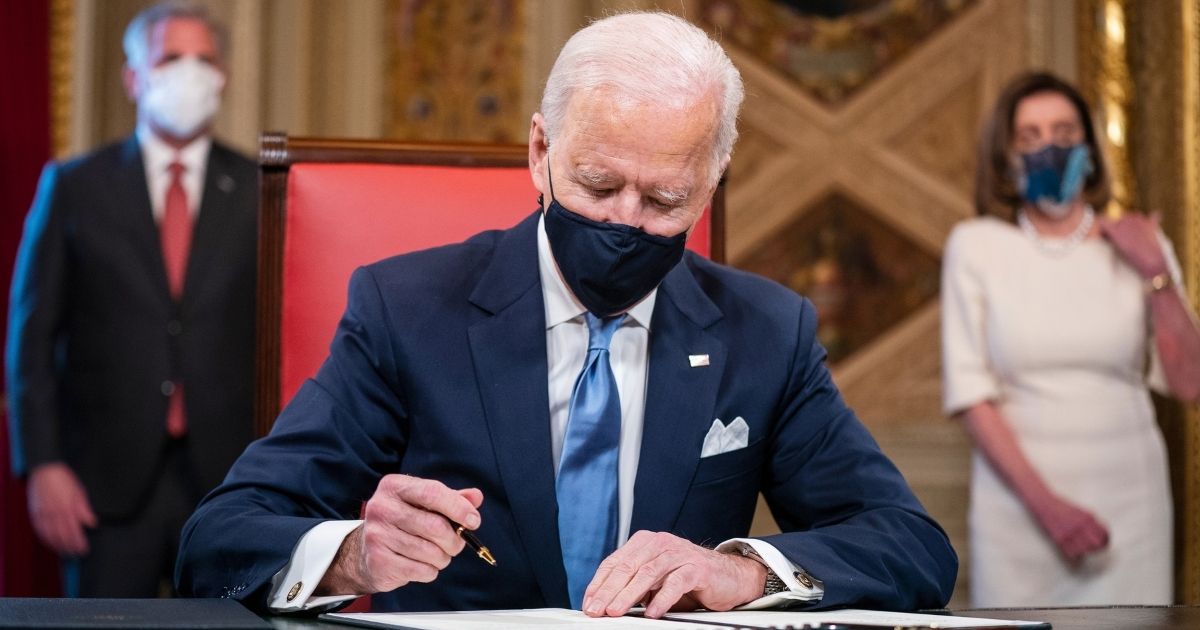 President Joe Biden signs three documents in the Presidents Room at the U.S. Capitol on Jan. 20, 2021, in Washington, D.C.