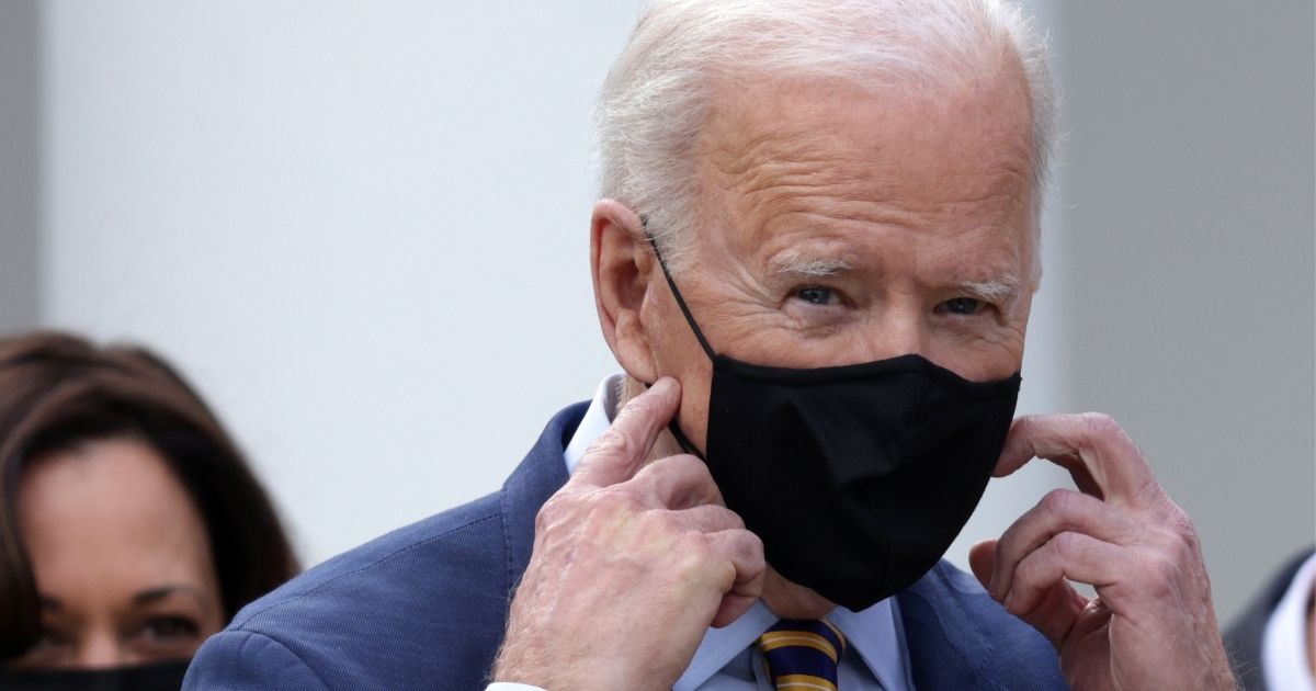 President Joe Biden takes off his mask during an event on the American Rescue Plan in the Rose Garden of the White House on Friday in Washington, D.C.