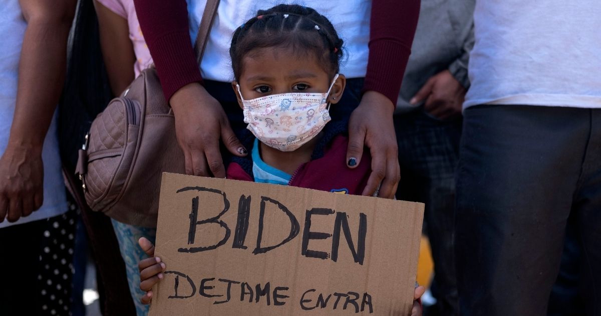 Dareli Matamoros, a girl from Honduras, holds a sign asking President Joe Biden to let her in during a migrant demonstration demanding clearer United States migration policies, at San Ysidro crossing port in Tijuana, Baja California state, Mexico on Tuesday.