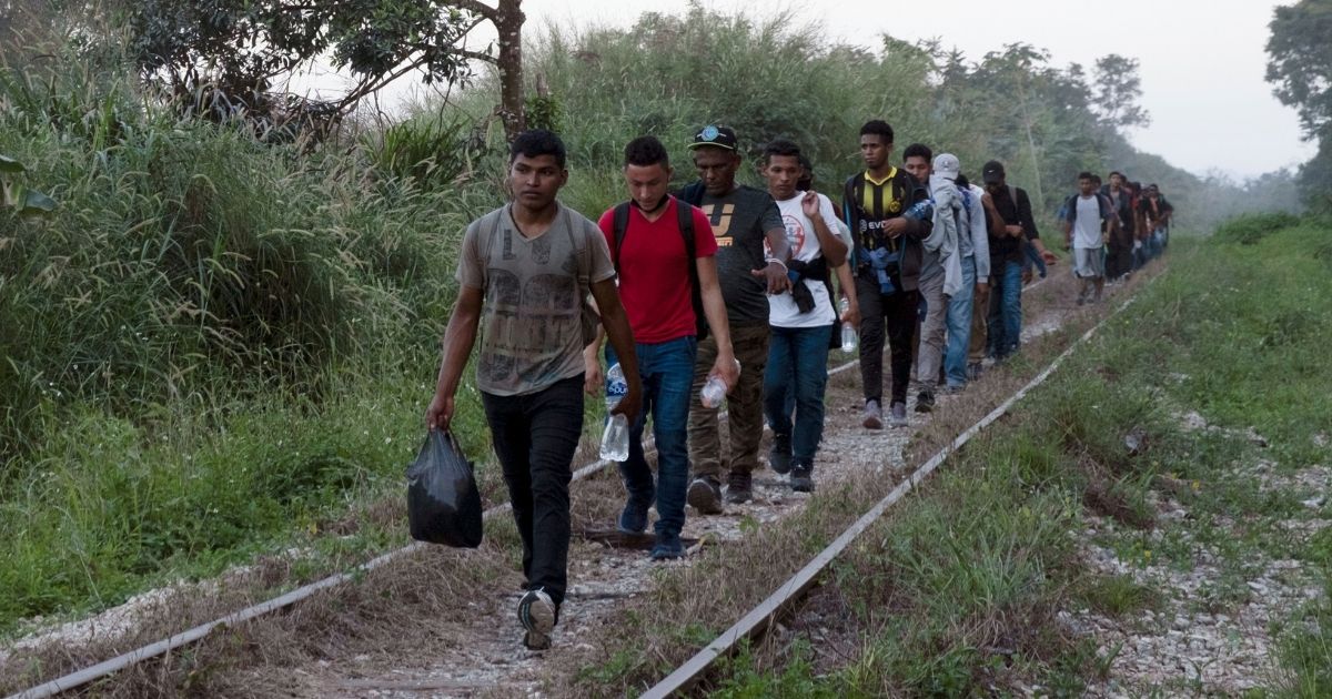 Migrants walk on train tracks on their journey to the U.S. border in Palenque, Chiapas state, Mexico, on Feb. 10, 2021.