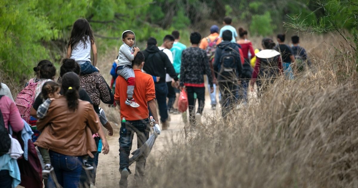 A group of migrants, most from Honduras, walk in an area near Mission, Texas, after crossing the Rio Grande from Mexico on Tuesday.