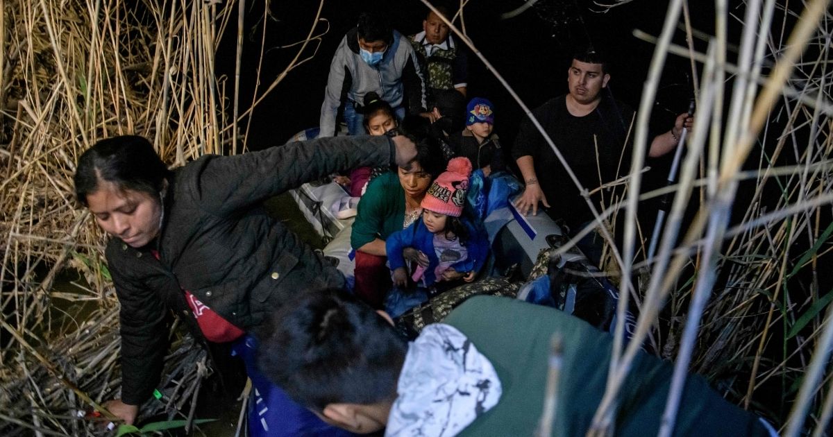 A group of migrants from Honduras and Guatemala arriving illegally from Mexico disembark from an inflatable boat onto the U.S. side of the Rio Grande near the Texas town of Roma on Sunday.